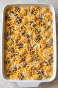 Unbaked tater tot breakfast casserole after adding the egg and milk mixture