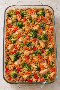 Overhead view of baked teriyaki chicken casserole with sauce-coated rice and mixed vegetables