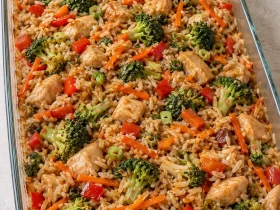 Teriyaki chicken casserole with rice, broccoli, carrots and red pepper in a glass baking dish