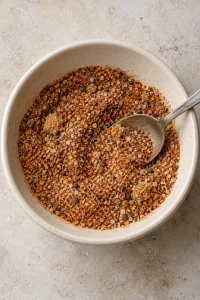 Partly mixed steak seasoning with small brown sugar clumps in the bowl.